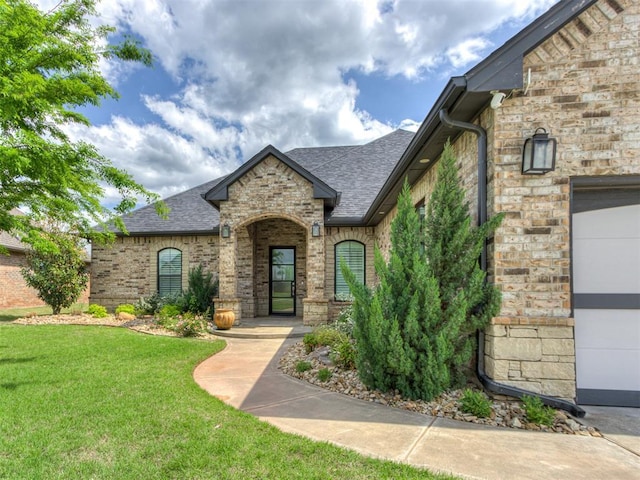 3108 Drake Crest Dr, Edmond, OK 73034 - entrance to property featuring a lawn, brick siding, an attached garage, and roof with shingles