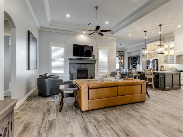 3108 Drake Crest Dr, Edmond, OK 73034 - living area featuring ceiling fan with notable chandelier, a wealth of natural light, a tile fireplace, and light wood-style flooring