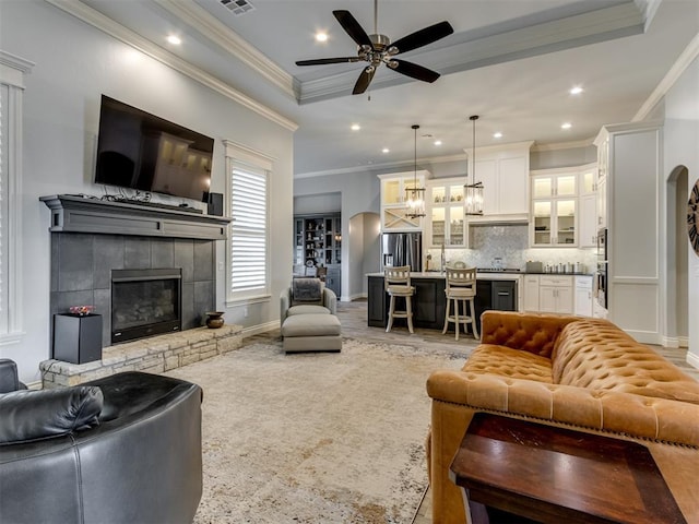 3108 Drake Crest Dr, Edmond, OK 73034 - living room with visible vents, a glass covered fireplace, recessed lighting, ornamental molding, and ceiling fan with notable chandelier