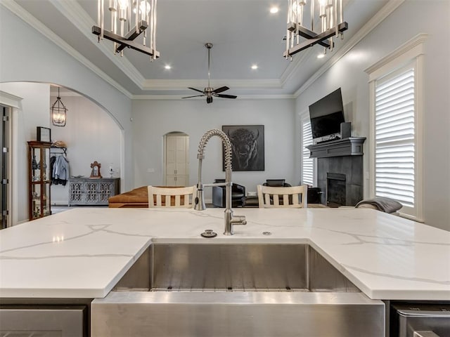 3108 Drake Crest Dr, Edmond, OK 73034 - kitchen with a tile fireplace, arched walkways, a sink, and open floor plan