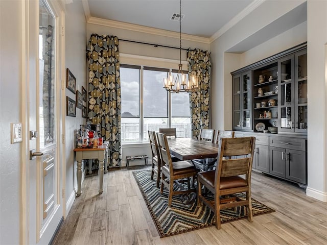 3108 Drake Crest Dr, Edmond, OK 73034 - dining area with an inviting chandelier, light wood-style flooring, ornamental molding, baseboards, and visible vents