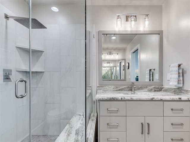 full bath featuring vanity, toilet, and a stall shower