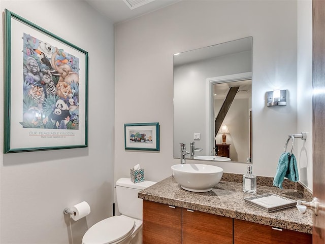 bathroom with a sink, double vanity, and toilet