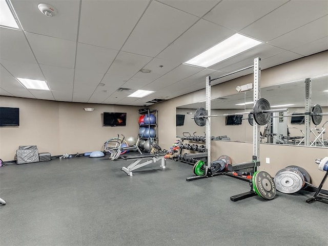 gym with a paneled ceiling