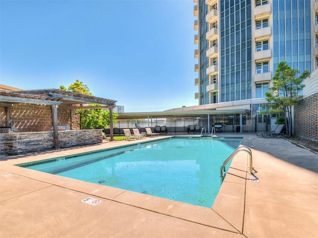 pool with a pergola, a patio area, and fence