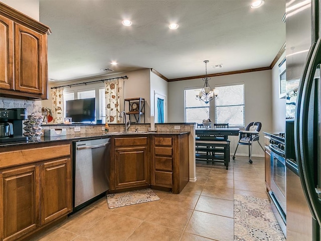 3515 Homesteaders Ln, Guthrie, OK 73044 - kitchen featuring a sink, recessed lighting, a chandelier, crown molding, and appliances with stainless steel finishes