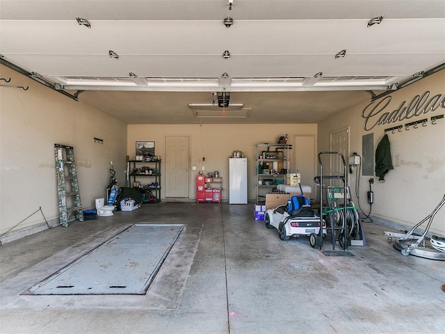 3515 Homesteaders Ln, Guthrie, OK 73044 - garage with a garage door opener, electric panel, and fridge