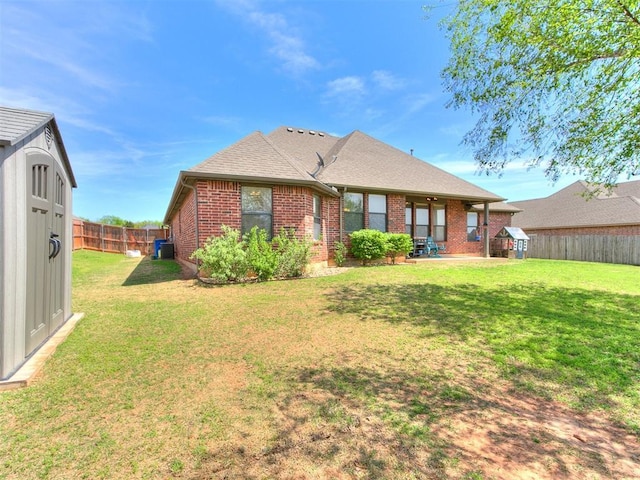 3515 Homesteaders Ln, Guthrie, OK 73044 - back of property featuring a storage shed, a lawn, a fenced backyard, and brick siding