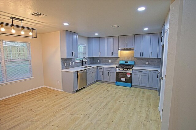 kitchen with a sink, visible vents, appliances with stainless steel finishes, and under cabinet range hood