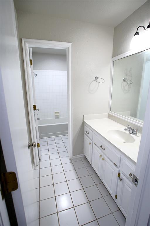 bathroom with shower / bathing tub combination, tile patterned flooring, and vanity