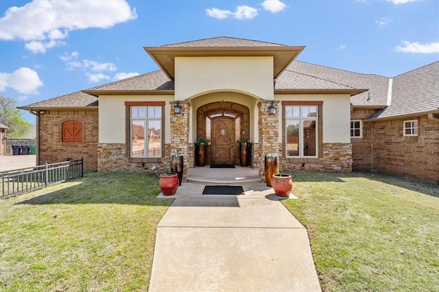 view of front of property with fence, a shingled roof, and a front yard