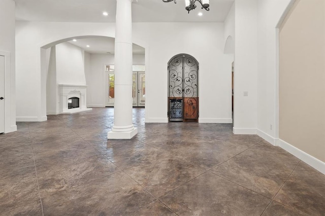 unfurnished living room with baseboards, concrete flooring, a large fireplace, and recessed lighting
