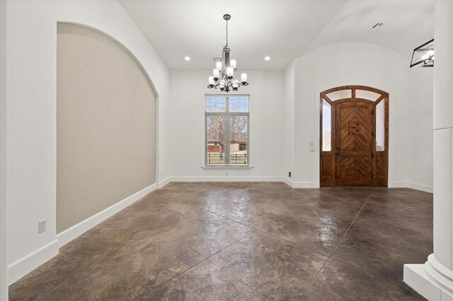 foyer entrance with concrete floors, a chandelier, arched walkways, baseboards, and recessed lighting
