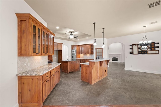 kitchen with open shelves, open floor plan, visible vents, and arched walkways