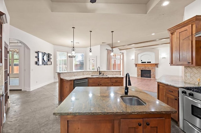 kitchen featuring brown cabinets, a sink, and a kitchen island with sink