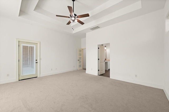 unfurnished bedroom featuring carpet flooring, baseboards, visible vents, access to outside, and a raised ceiling