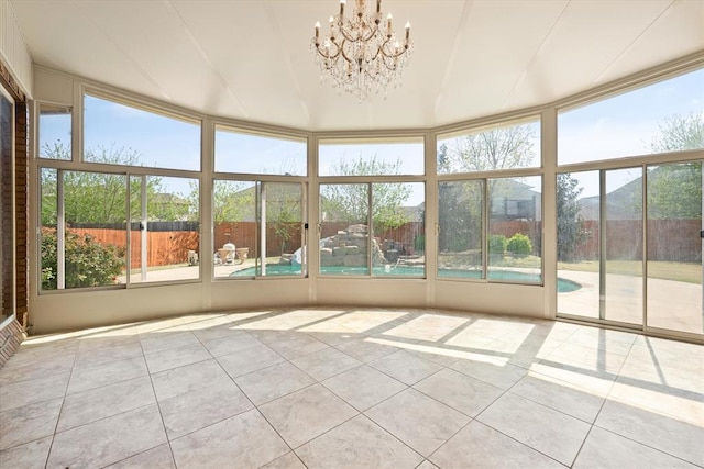 unfurnished sunroom featuring a notable chandelier and tile patterned flooring