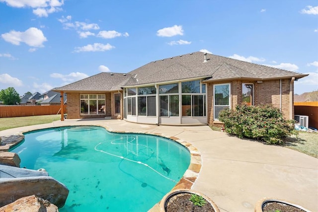 view of pool with a patio area, a fenced in pool, a sunroom, and fence