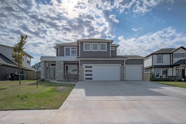 prairie-style home with an attached garage, a front yard, concrete driveway, and fence