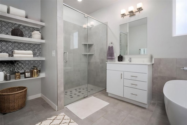 bathroom featuring vanity, tile patterned flooring, a freestanding bath, and a stall shower