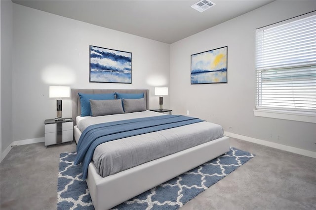 bedroom with carpet floors, visible vents, and baseboards