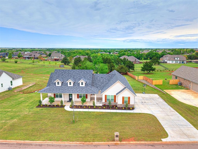 view of front of house with covered porch, a front lawn, a residential view, and driveway
