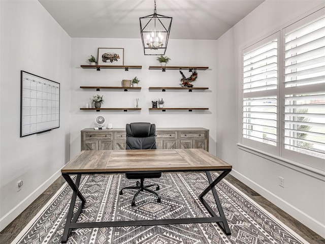 office space featuring baseboards, wood finished floors, and a notable chandelier