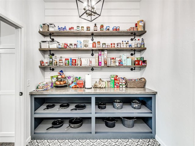bar featuring baseboards and an inviting chandelier