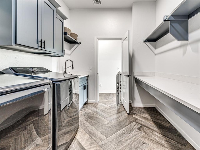 laundry area featuring visible vents, washer and clothes dryer, cabinet space, and baseboards