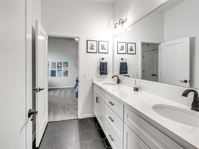 ensuite bathroom featuring double vanity, ensuite bathroom, tile patterned flooring, and a sink