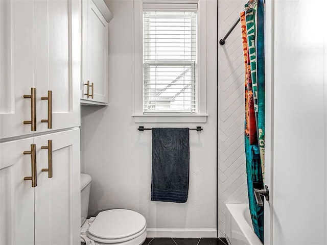 full bath with tile patterned floors, shower / tub combo, a healthy amount of sunlight, and toilet