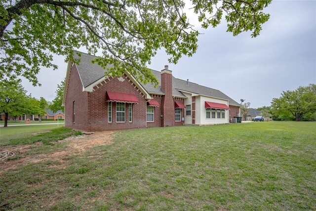 2400 Whiteoak Dr, Blanchard, OK 73010 - rear view of house featuring brick siding, a yard, a shingled roof, and a chimney