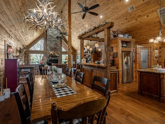 2010 Shady Cv, Sulphur, OK 73086 - dining space featuring visible vents, ceiling fan with notable chandelier, wood ceiling, hardwood / wood-style flooring, and high vaulted ceiling