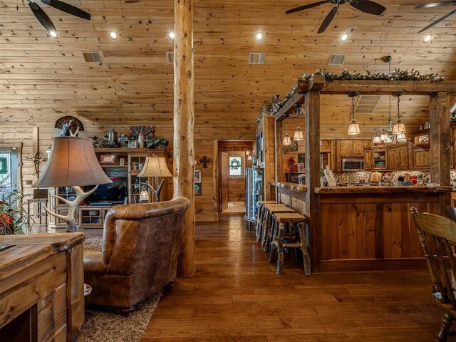 2010 Shady Cv, Sulphur, OK 73086 - living area featuring hardwood / wood-style floors, a ceiling fan, visible vents, and wooden walls
