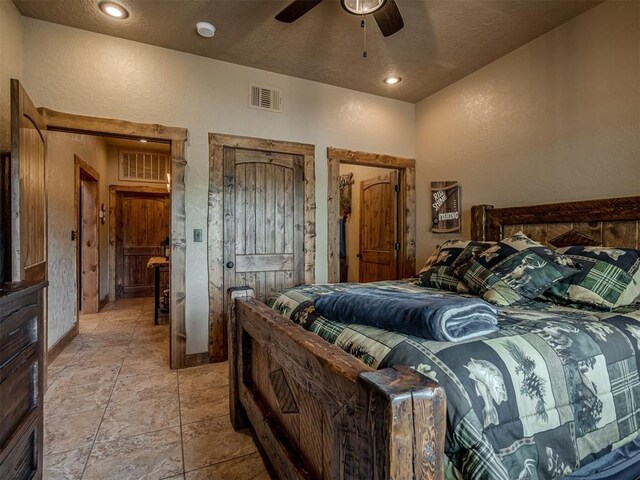 2010 Shady Cv, Sulphur, OK 73086 - bedroom featuring stone tile flooring, a textured wall, visible vents, and baseboards
