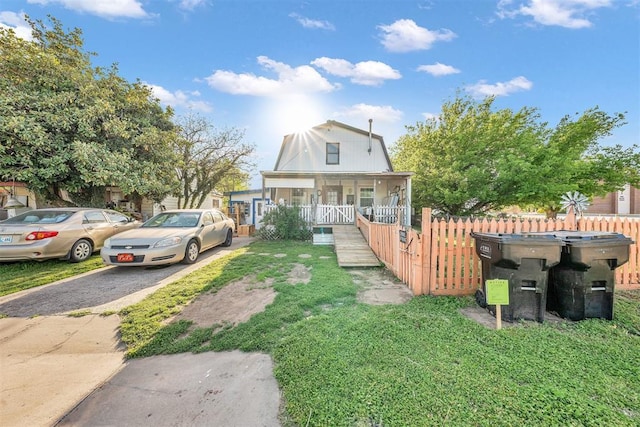 319 S Main St, Pocasset, OK 73079 - colonial inspired home featuring aphalt driveway, a front lawn, covered porch, and fence