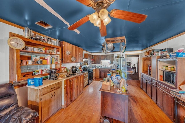 319 S Main St, Pocasset, OK 73079 - kitchen with range hood, black gas range oven, open shelves, light wood-type flooring, and ceiling fan