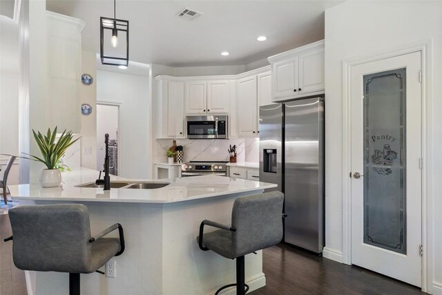 2201 Pine View Ter, Edmond, OK 73003 - kitchen featuring stainless steel appliances, a sink, a breakfast bar area, white cabinetry, and recessed lighting