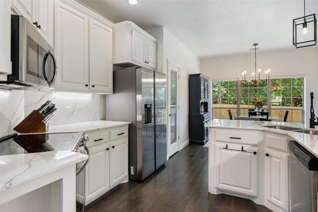2201 Pine View Ter, Edmond, OK 73003 - kitchen with stainless steel appliances, a sink, a chandelier, dark wood-style floors, and white cabinets