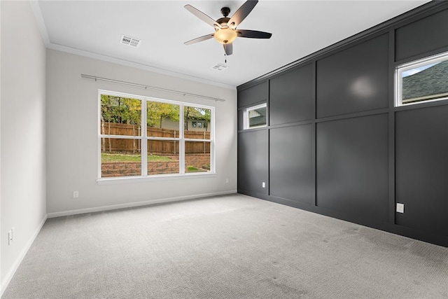 unfurnished room featuring visible vents, ornamental molding, baseboards, and light carpet