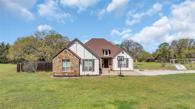 130 Quail Dr, Healdton, OK 73438 - tudor home with a front lawn, fence, and stone siding