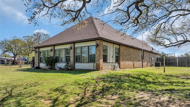 130 Quail Dr, Healdton, OK 73438 - view of side of property with a shingled roof, fence, a yard, cooling unit, and brick siding