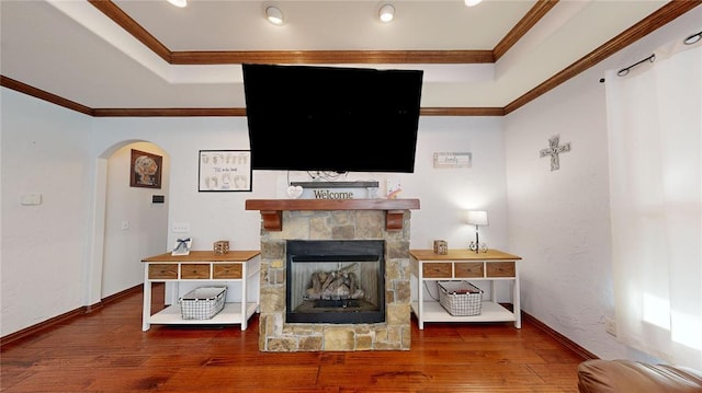 130 Quail Dr, Healdton, OK 73438 - living room featuring a tray ceiling, arched walkways, wood finished floors, a fireplace, and ornamental molding