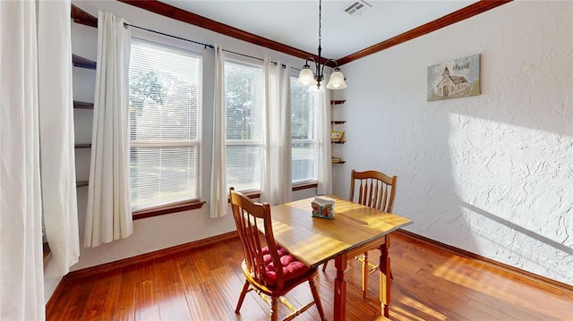 130 Quail Dr, Healdton, OK 73438 - dining area with a textured wall, wood-type flooring, baseboards, ornamental molding, and visible vents