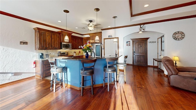 130 Quail Dr, Healdton, OK 73438 - kitchen with arched walkways, a ceiling fan, a breakfast bar area, and stainless steel appliances