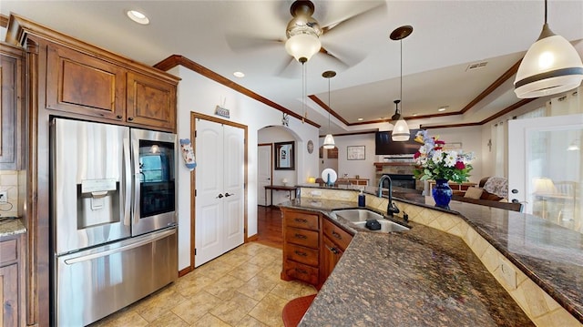 130 Quail Dr, Healdton, OK 73438 - kitchen featuring crown molding, a ceiling fan, a sink, brown cabinetry, and stainless steel fridge