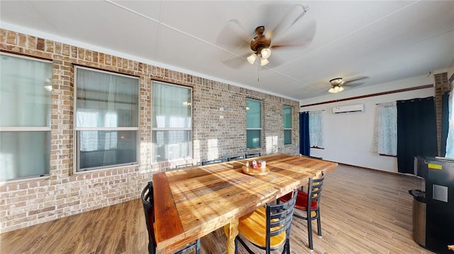 130 Quail Dr, Healdton, OK 73438 - dining space featuring ceiling fan, wood finished floors, brick wall, and a wall mounted AC