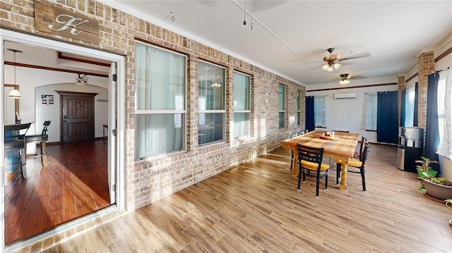 130 Quail Dr, Healdton, OK 73438 - dining space featuring brick wall, wood finished floors, a wealth of natural light, and ceiling fan
