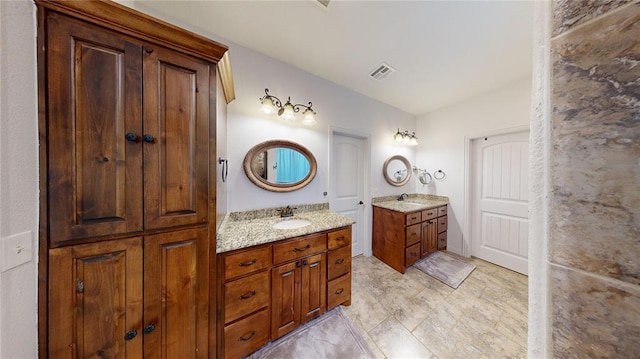 130 Quail Dr, Healdton, OK 73438 - bathroom featuring two vanities, visible vents, and a sink