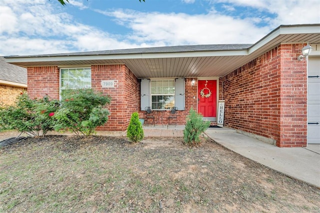 7909 Chumley Ln, Oklahoma City, OK 73135 - view of exterior entry featuring brick siding and covered porch